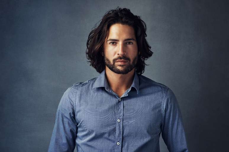 O corte longo desconectado e a barba média oferecem estilo ao visual 