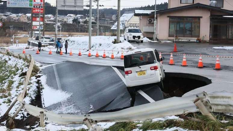 Um carro ficou preso em uma estrada que desabou em Tohoku, no norte do Japão