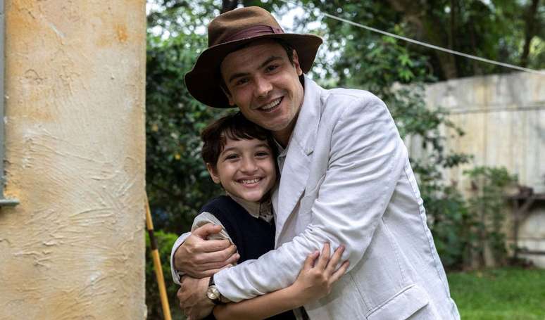 Candinho (Sergio Guizé) e Samir (Davi Malizia) em 'Êta Mundo Melhor' se abraçam após revelação de paternidade.