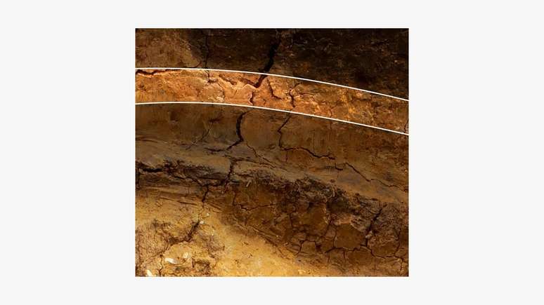 Mas esta é a camada importante. É a mesma argila marrom-amarelada de baixo, mas com coloração um pouco mais avermelhada