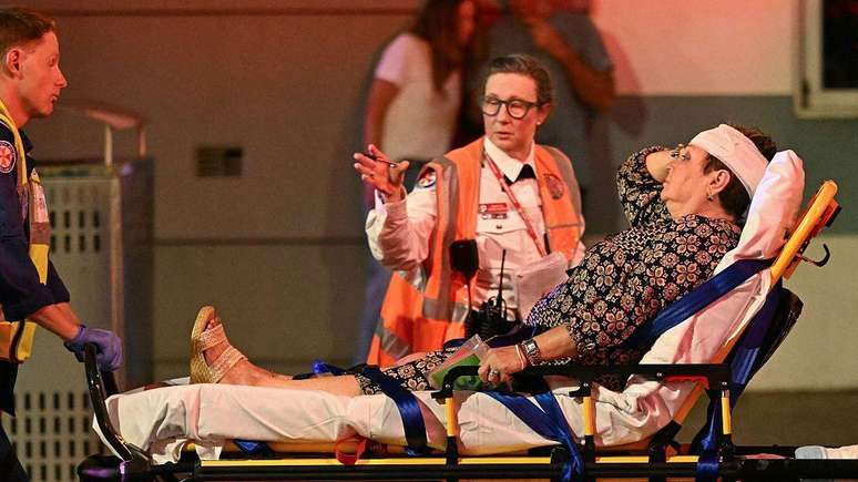 Uma mulher ferida recebe atendimento de paramédicos na praia de Bondi.