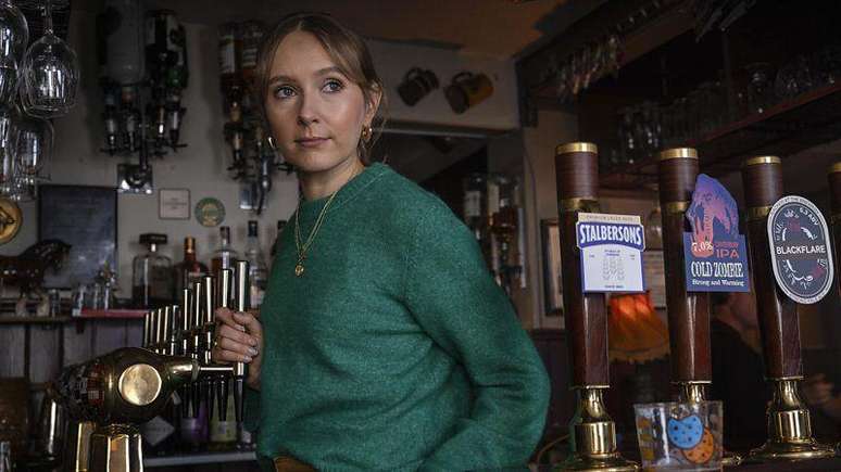 Rose Ayling-Ellis em um bar, em cena de "Code of Silence"