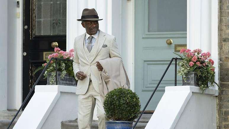 Lennie James (Barrington Loverman) desce uma escada em cena de 'Mr. Loverman'