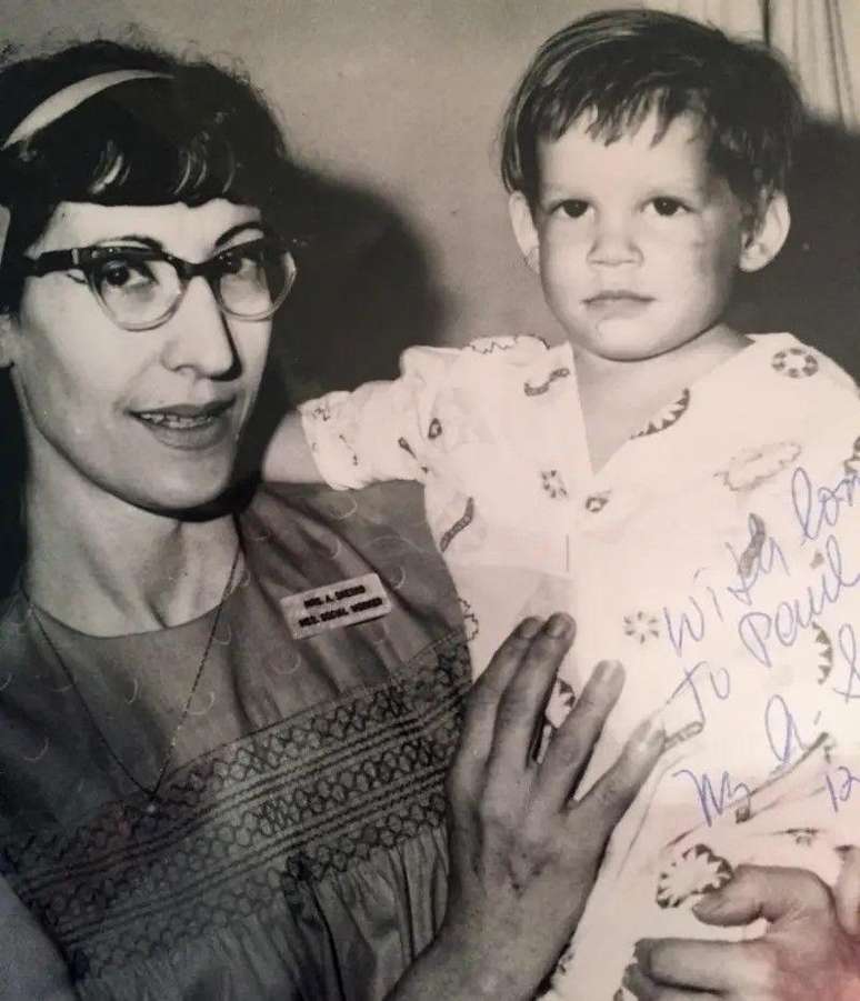 Uma agente do servi&ccedil;o social segura o beb&ecirc; rec&eacute;m encontrado, com um machucado no rosto