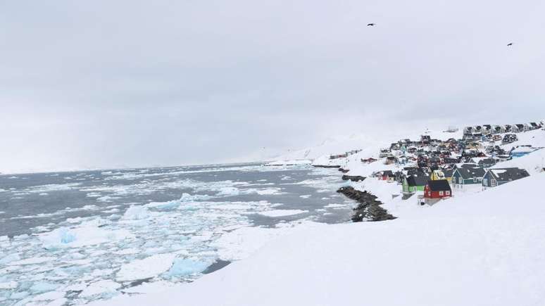 Vista da cidade velha de Nuuk, na Groenl&acirc;ndia, com casas de madeira coloridas rodeadas pela neve e pelo gelo
