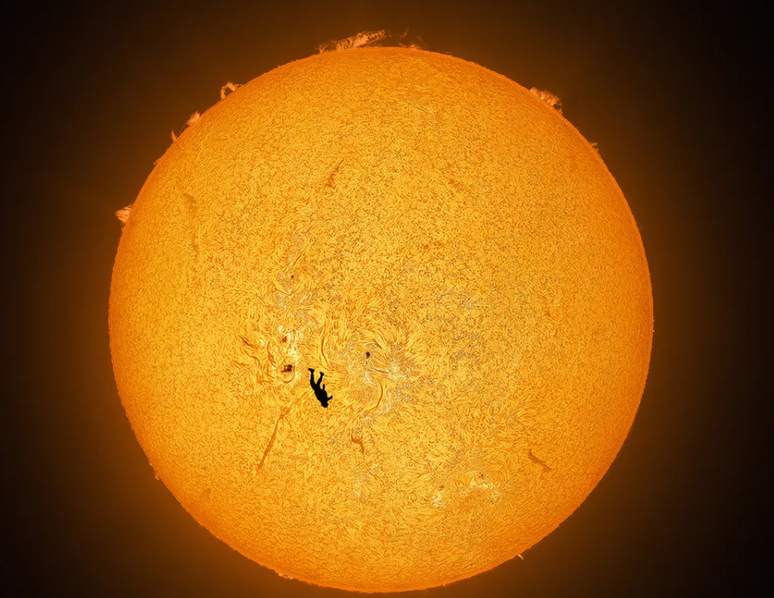 Sol e um paraquedista sobrepostos em imagem