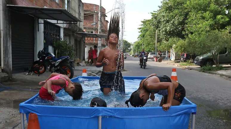 Children cool off in water to ease intense heat during a heatwave recorded in Rio de Janeiro in 2023