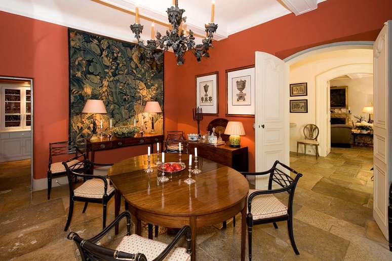 A sala de almo&ccedil;o do casar&atilde;o tem objetos de antiqu&aacute;rio, como a tape&ccedil;aria de parede, o lustre e os candelabros