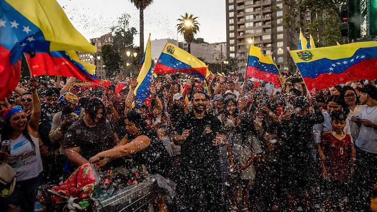 Pessoas em Santiago do Chile, comemorando a queda de Nicol&aacute;s Maduro no s&aacute;bado, 3 de janeiro de 2026