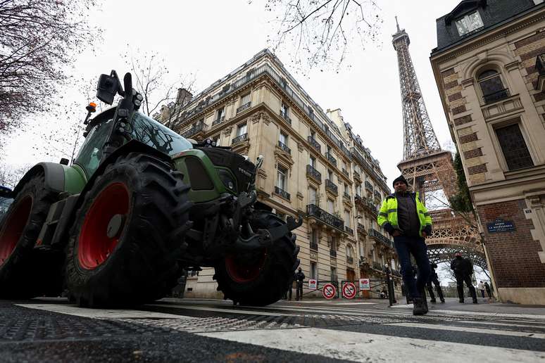 Policiais ao lado de tratores bloqueando uma estrada perto da Torre Eiffel, enquanto agricultores franceses protestam contra a gest&atilde;o do governo em rela&ccedil;&atilde;o ao acordo de livre com&eacute;rcio UE-Mercosul, em Paris, Fran&ccedil;a, 8 de janeiro de 2026.