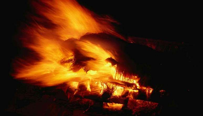 chamas de uma pira contra um fundo preto escuro
