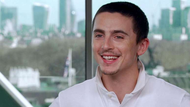 తిమోతీ చలమెట్ BBC న్యూస్‌తో తన ఇంటర్వ్యూలో తెల్లటి పోలో చొక్కా ధరించి, నేపథ్యంలో లండన్‌ను చూపుతున్న గాజు కిటికీ ముందు నవ్వుతున్నాడు