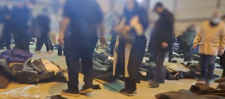 Um grupo de pessoas tenta identificar seus entes queridos entre os corpos no necrot&eacute;rio de Kahrizak