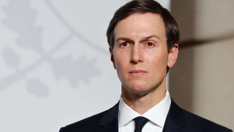 Jared Kushner, vestido com um terno preto e camisa branca, olha para o horizonte.