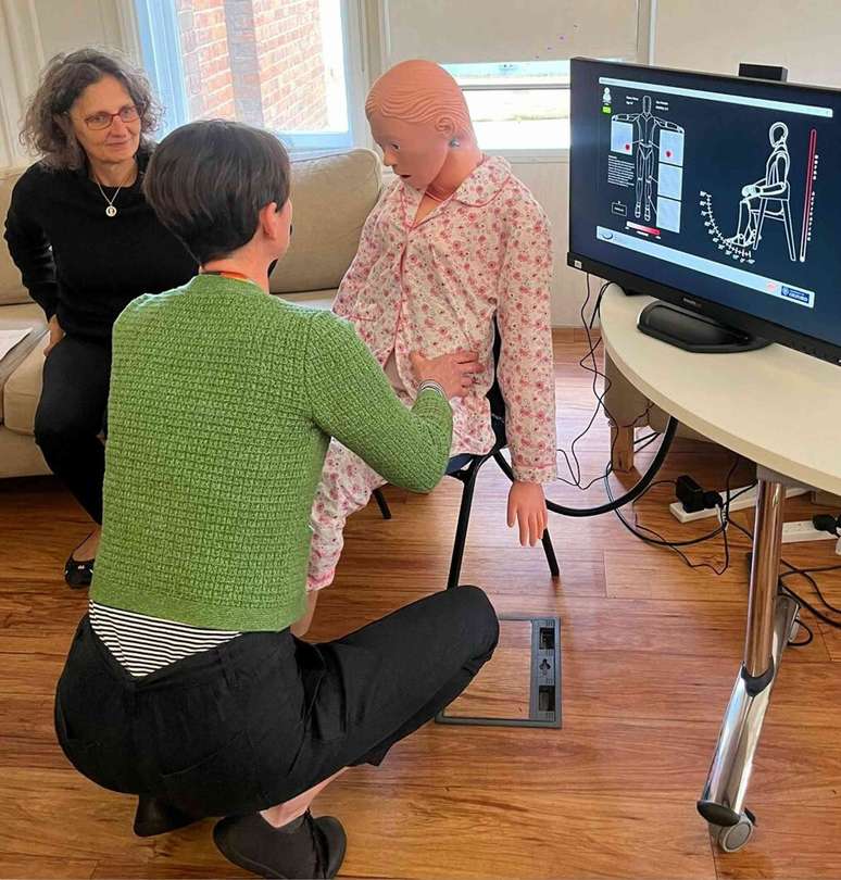 A terapeuta ocupacional Ruth Alecock usa o rob&ocirc; de treinamento &lsquo;Mona&rsquo;