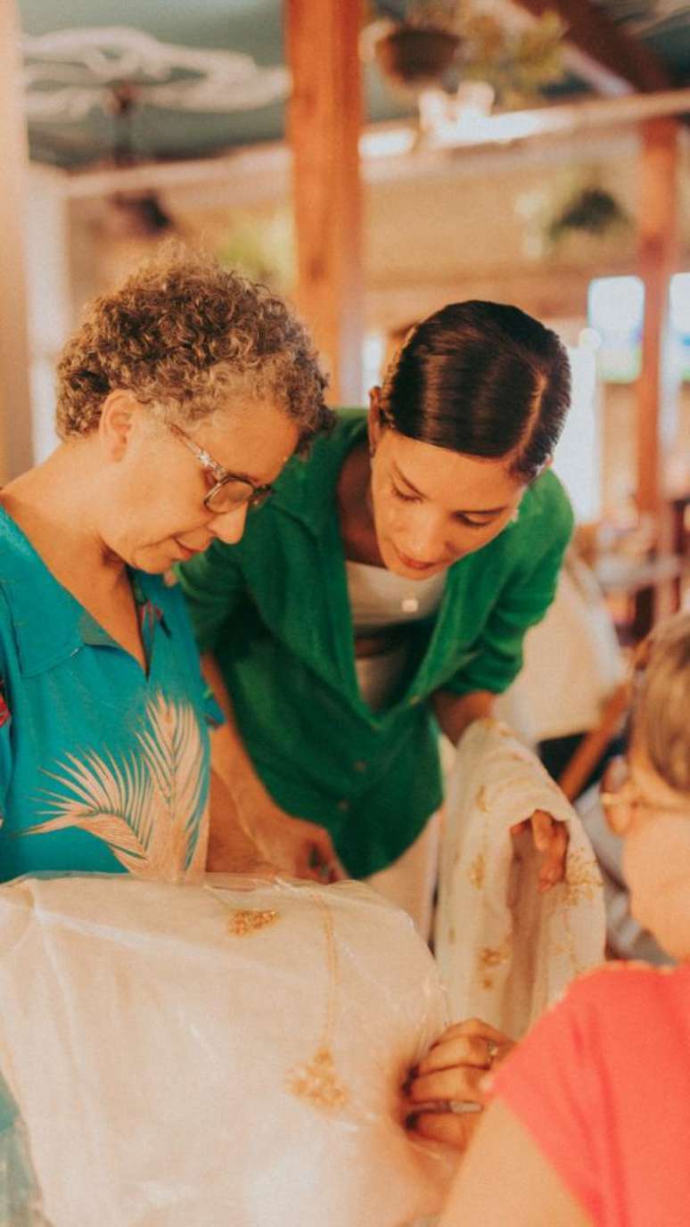 Thayn&aacute; Soares ao lado de bordadeira 