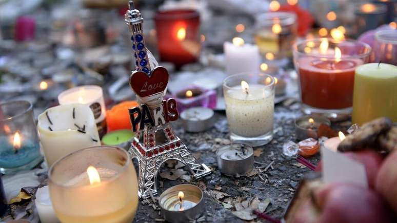Velas, flores e uma estatueta da Torre Eiffel depositadas em frente &agrave; sala de espet&aacute;culos do Bataclan, em Paris, em 15 de novembro de 2015, dois dias ap&oacute;s o terr&iacute;vel ataque terrorista no local.