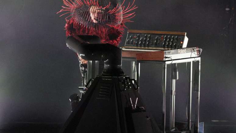 Lady Gaga no palco usando um chap&eacute;u em forma de abajur com c&iacute;lios