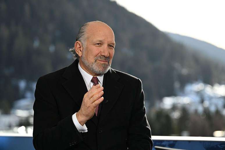 Howard Lutnick colocando uma das m&atilde;os sobre a gravata. Ele usa um terno preto. 