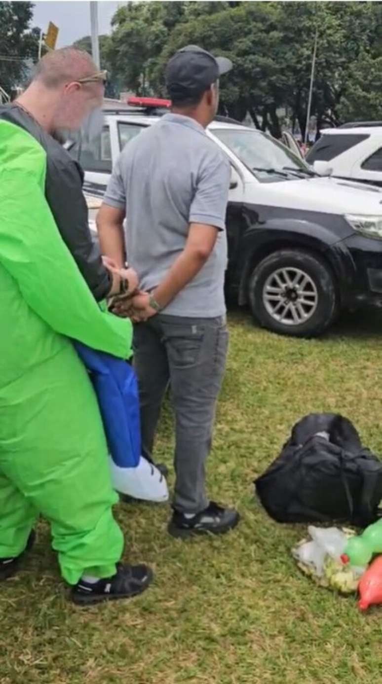 Policiais civis fantasiados de extraterrestres prendem suspeitos de vender bebida adulterada.