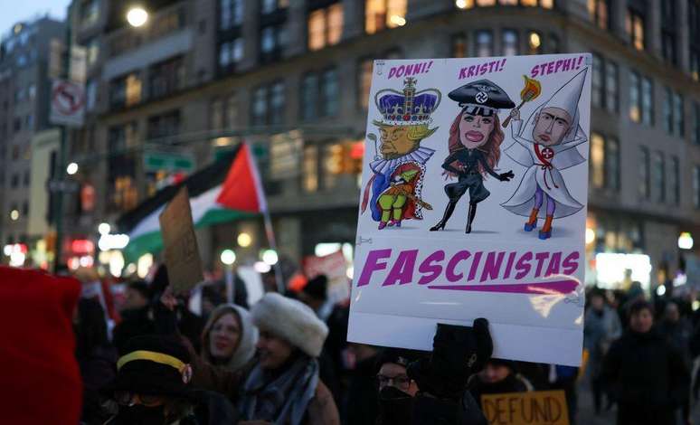 Manifestantes em Nova York retratam Stephen Miller ao lado de Kristi Noem e Donald Trump