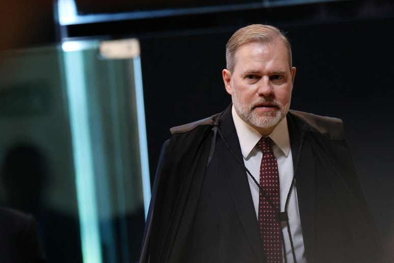 మంత్రి డయాస్ టోఫోలీ టోగా ధరించి నడుచుకుంటున్నారు