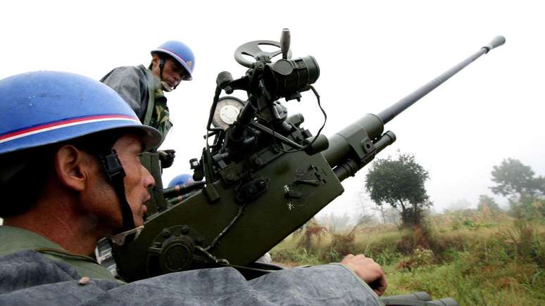 Funcion&aacute;rios do departamento meteorol&oacute;gico chin&ecirc;s se preparam para disparar proj&eacute;teis de artilharia para semeadura de nuvens em Yongchuan, em 2009