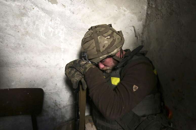 மே 2022 இல் உக்ரேனிய சிப்பாய் துப்பாக்கியில் சாய்ந்துள்ளார்