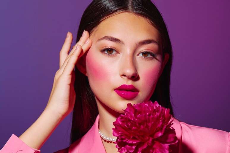 O blush deixa de ser detalhe e passa a estruturar a maquiagem, criando um efeito corado intenso 