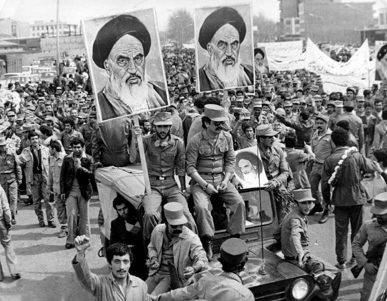 O Ex&eacute;rcito da Rep&uacute;blica Isl&acirc;mica do Ir&atilde; marcha nas ruas em solidariedade &agrave; popula&ccedil;&atilde;o durante a revolu&ccedil;&atilde;o iraniana. Eles carregam cartazes com o rosto de Khomeini