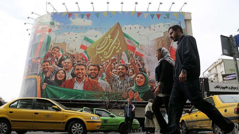 Pessoas caminham pelas ruas da capital iraniana, Teer&atilde;, enquanto a vida cotidiana segue seu curso