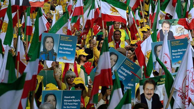 Manifestantes com bandeiras do Ir&atilde; e fotografias de Massoud e Maryam Rajavi