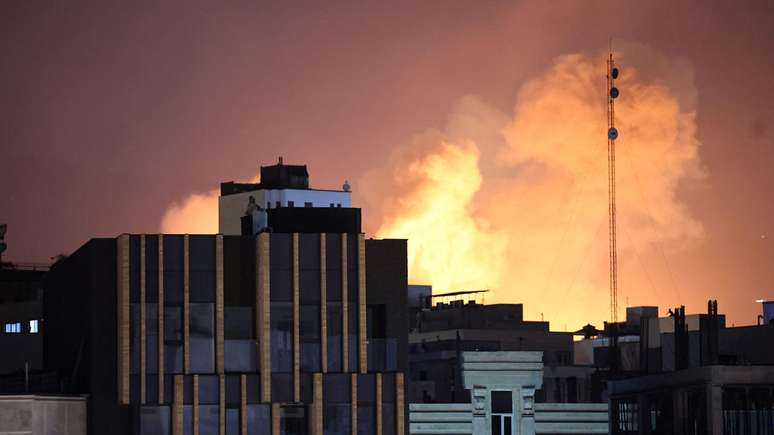 Fuma&ccedil;a saindo   atr&aacute;s de pr&eacute;dios ap&oacute;s uma explos&atilde;o no segundo dia consecutivo de ataques dos EUA e de Israel, em Teer&atilde;.