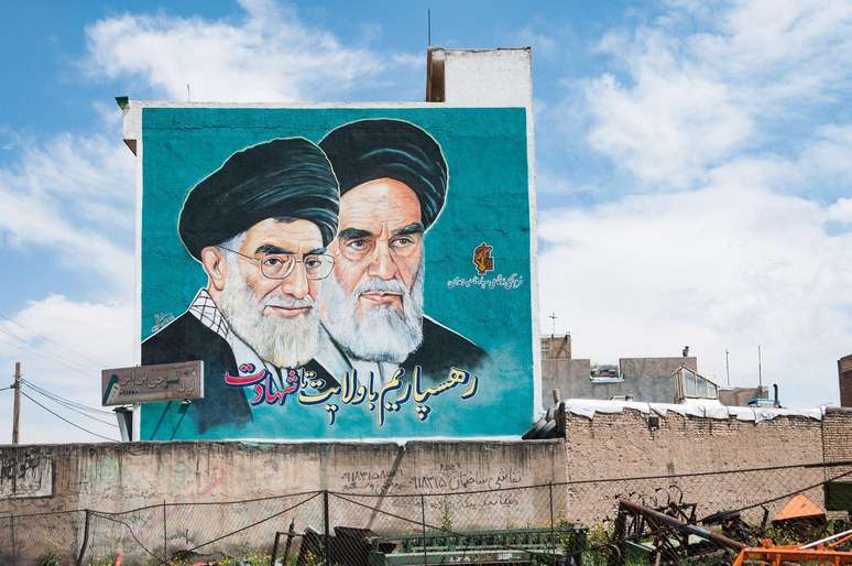 Mural em Hamadan, no oeste do Ir&atilde;, com retratos do aiatol&aacute; Ruhollah Khomeini (&agrave; direita), o primeiro l&iacute;der supremo ap&oacute;s a Revolu&ccedil;&atilde;o Isl&acirc;mica, e do aiatol&aacute; Ali Khamenei (&agrave; esquerda), que foi seu sucessor e morreu no &uacute;ltimo s&aacute;bado (28/2)