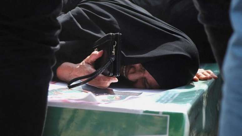 Mulher chora deitada em um caix&atilde;o