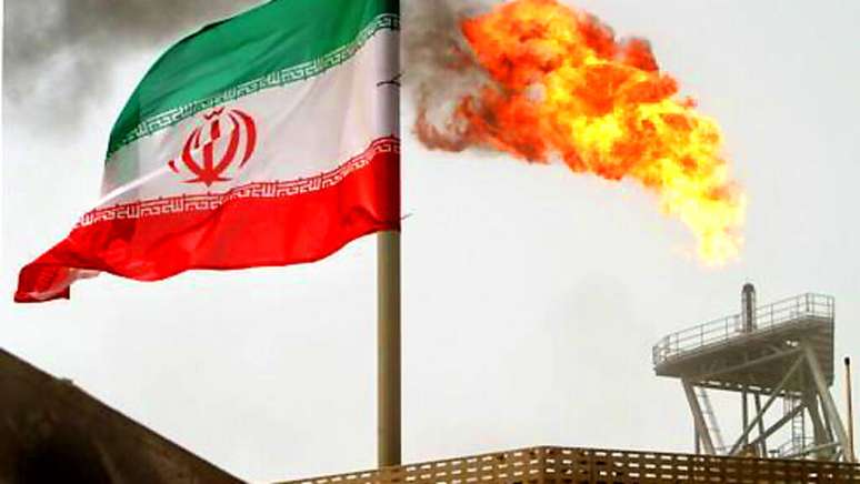 Foto de ilustra&ccedil;&atilde;o. A bandeira iraniana sobre os campos petrol&iacute;feros de Soroush, no Golfo P&eacute;rsico.