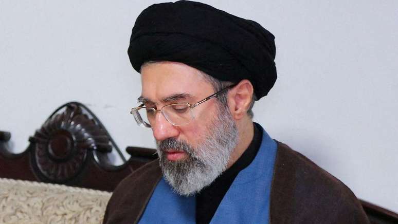Usando um turbante preto e &oacute;culos, Mojtaba Khamenei &eacute; fotografado durante uma visita ao escrit&oacute;rio do Hezbollah em Teer&atilde;, em 2024.