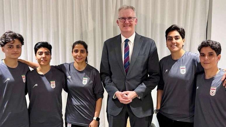 O ministro da Imigra&ccedil;&atilde;o da Austr&aacute;lia, Tony Burke, com as cinco jogadoras que receberam vistos humanit&aacute;rios