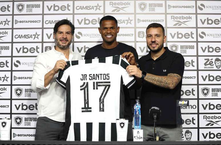 J&uacute;nior Santos recebe o manto ao lado dos diretores L&eacute;o Coelho e Alessandro Brito &ndash;