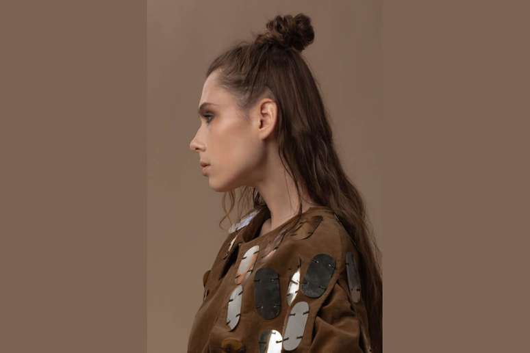 Com parte dos fios presos em um pequeno coque no topo da cabe&ccedil;a, o visual combina praticidade e movimento, mantendo o restante do cabelo solto e cheio de leveza 