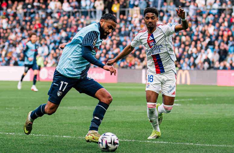Boufal, doLe Havre (de azul,) corre pela bola. Mas o brasileiro Abner, chega junto para fazer a marca&ccedil;&atilde;o.&nbsp; divulga&ccedil;&atilde;o/X/Le Havre