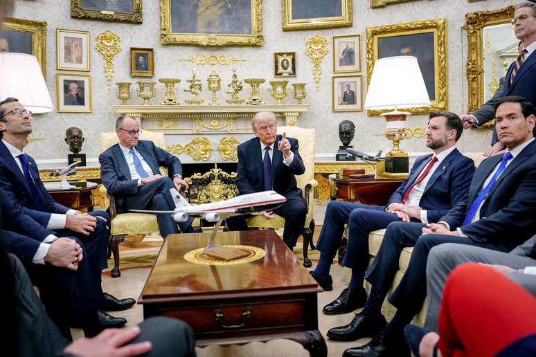 Marco Rubio, sentado na direita da foto, com gravata azul, virou meme pelos sapatos grandes