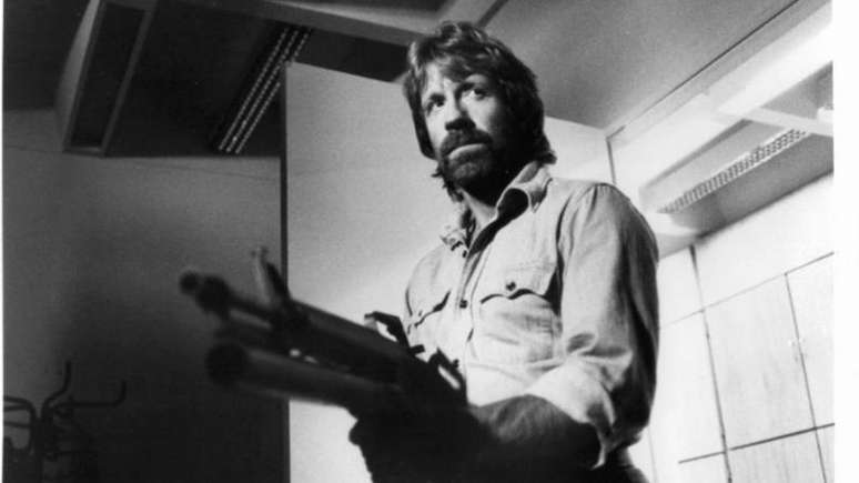 Chuck Norris fortemente armado em uma cena do filme Invas&atilde;o dos EUA, de 1985