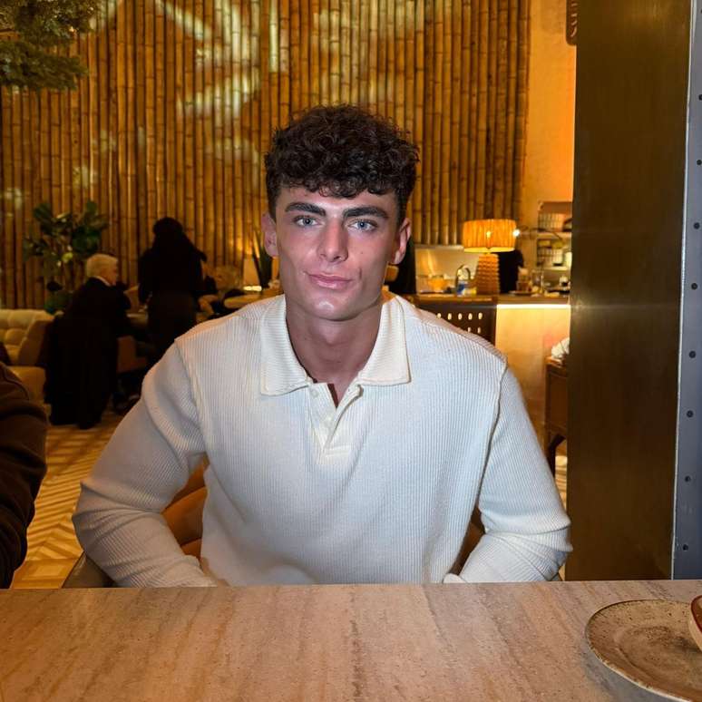 Tom Thebe sentado &agrave; mesa de um restaurante