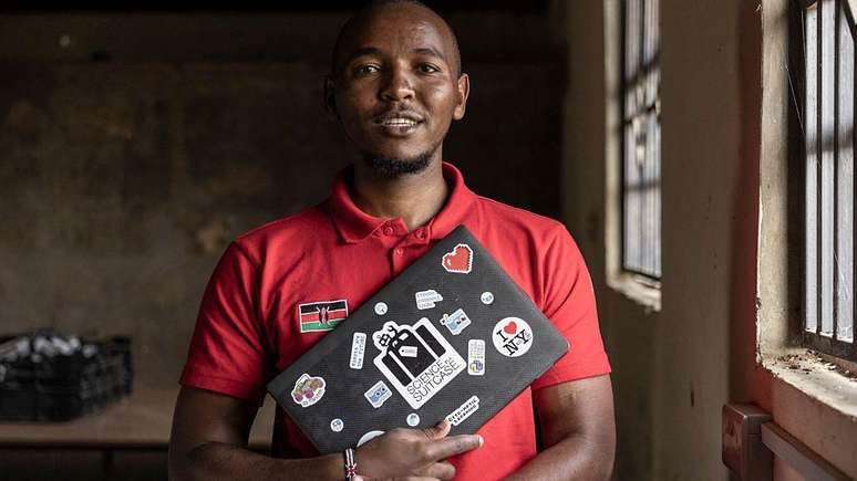 Um jovem na Nig&eacute;ria segurando um notebook.