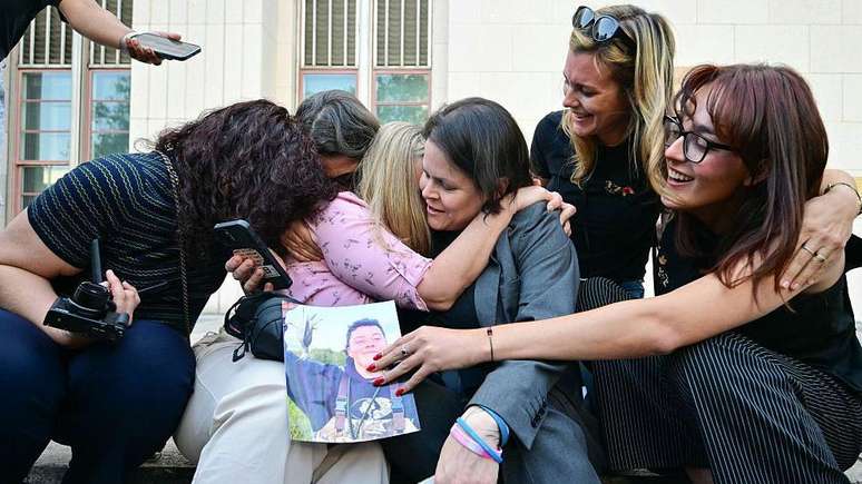 புதன்கிழமை, லாஸ் ஏஞ்சல்ஸ் உயர் நீதிமன்றத்தின் முன் படிகளில் சமூக ஊடக பாதிக்கப்பட்டோர் சட்ட மையத்தின் வாதிகளின் வழக்கறிஞர் பாதிக்கப்பட்டவர்களின் குடும்ப உறுப்பினர்களைக் கட்டிப்பிடித்தார்.