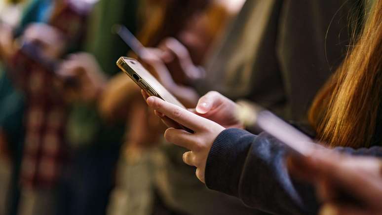 இளைஞர்கள் குழு தங்கள் ஸ்மார்ட்போன்களைப் பார்க்கிறது.