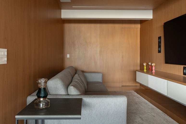 Quando aplicado na sala, o painel de madeira valoriza o espa&ccedil;o e melhora a ac&uacute;stica, tornando o ambiente mais acolhedor para momentos de lazer Projeto: Camila Palladino |