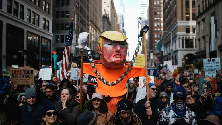 Manifestantes carregam uma figura de Trump em Nova York