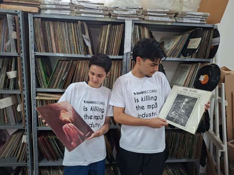 Gabriela e Lucas, da equipe da Vinil Records, com discos 'Trindade' e 'Let Me Sing' de Raul Seixas